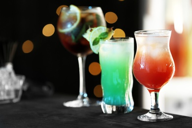 Row of different fresh alcoholic cocktails on bar counter