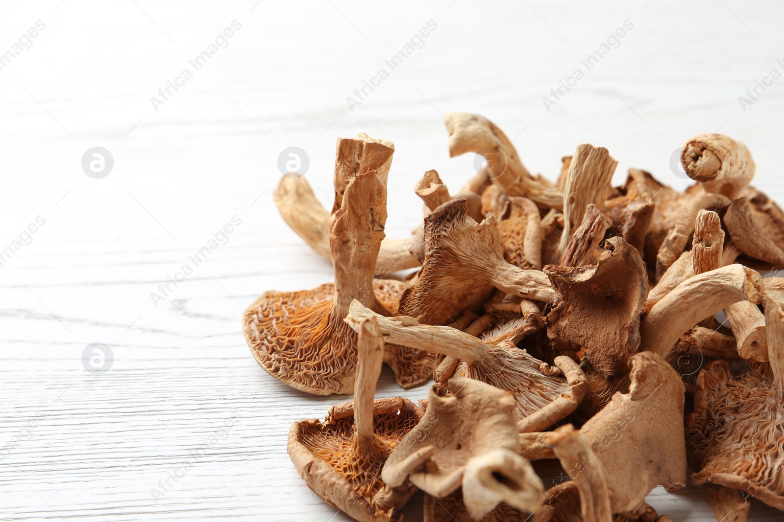 Photo of Dried mushrooms on wooden background, closeup. Space for text