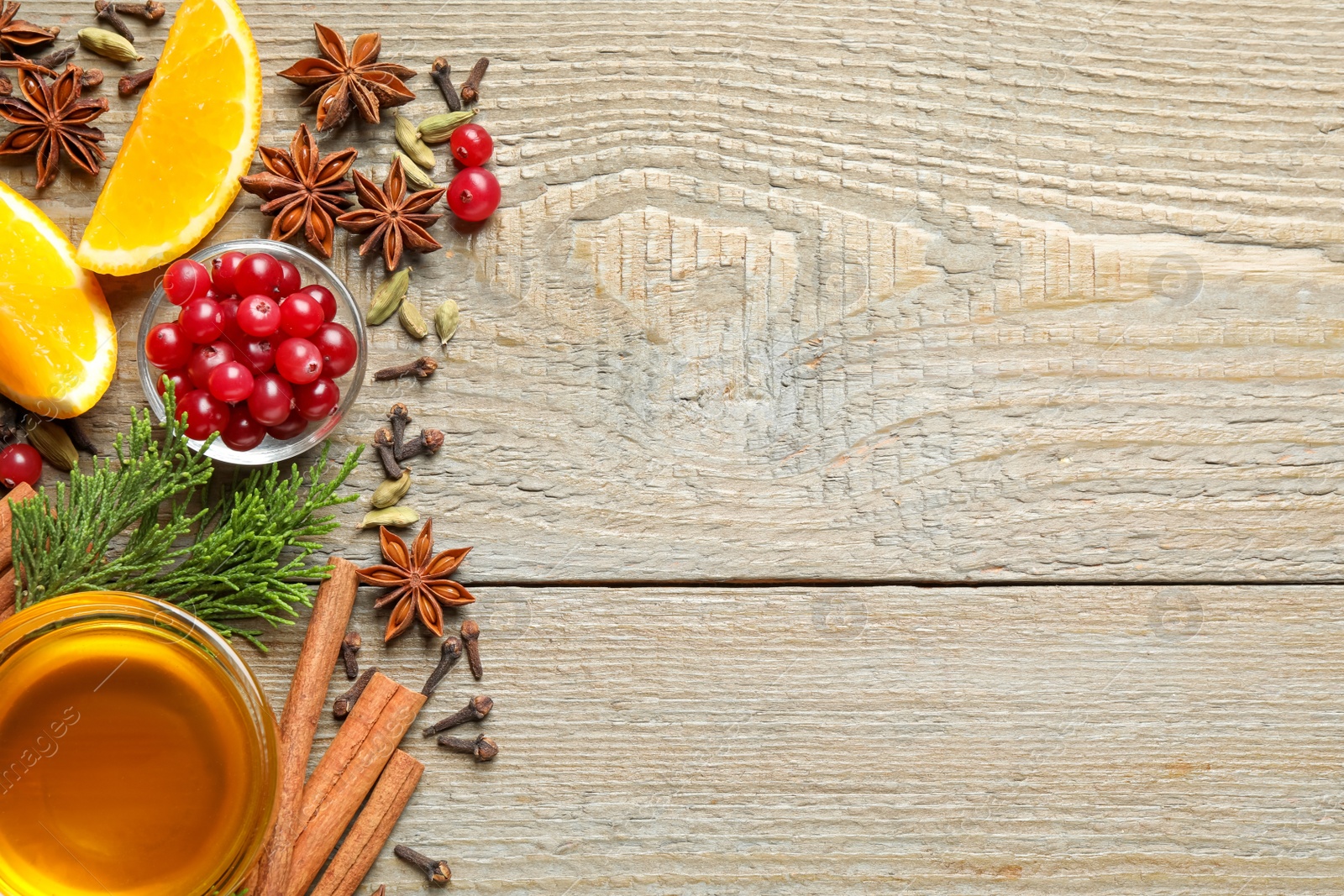 Photo of Flat lay composition with mulled wine ingredients on wooden table. Space for text