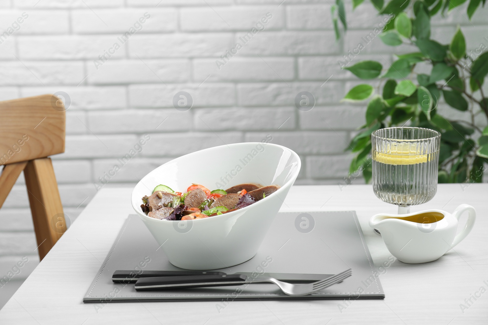 Photo of Delicious salad with beef tongue and vegetables served on white wooden table indoors. Space for text