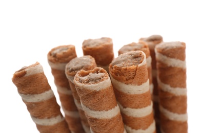 Photo of Tasty wafer roll sticks on white background, closeup. Crispy food