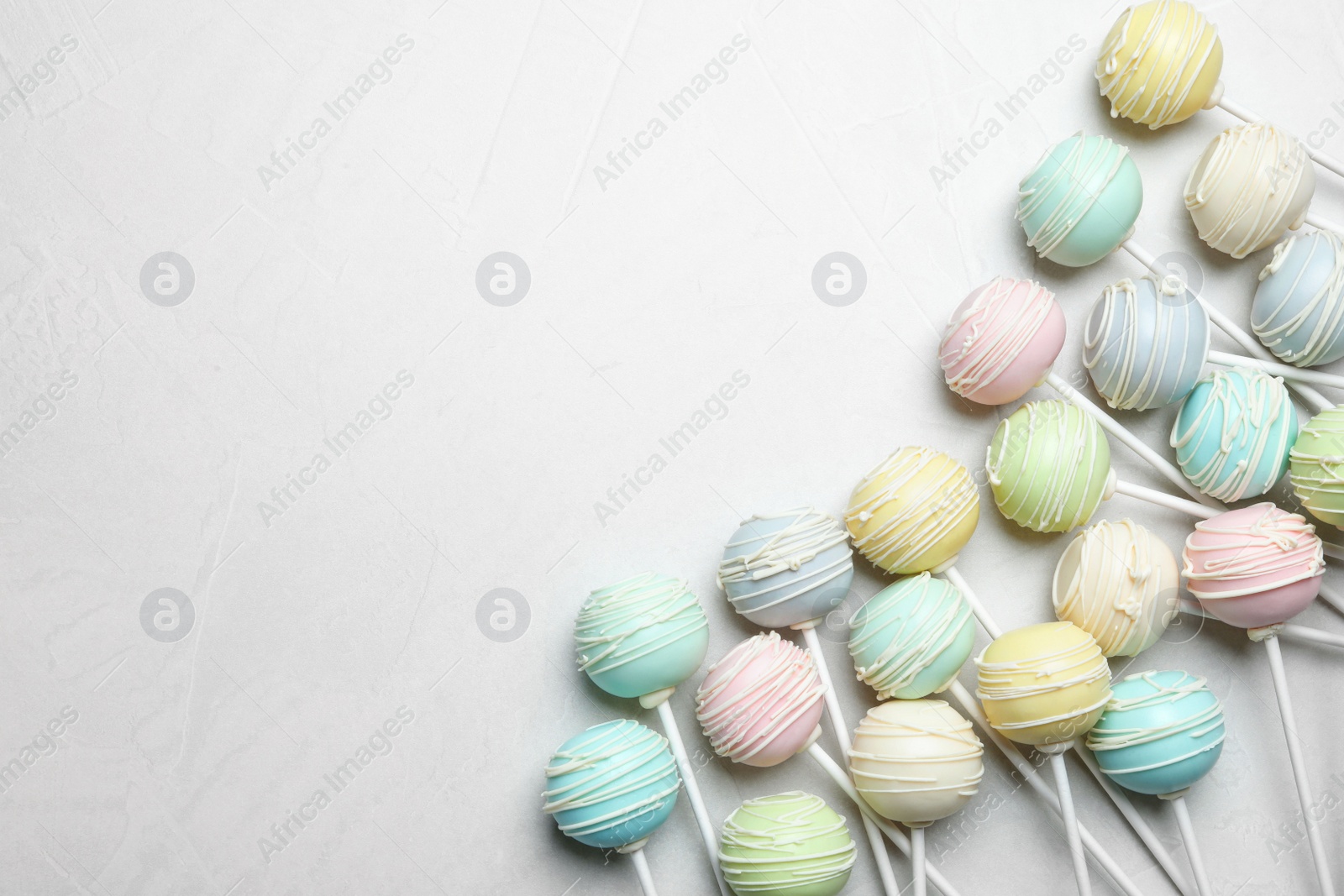 Photo of Sweet cake pops on light grey background, flat lay. Space for text