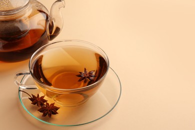 Aromatic tea with anise stars on beige background. Space for text