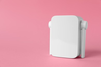New modern Wi-Fi repeater on pink background, space for text