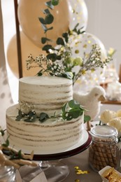 Photo of Beautiful cake and other treats on table in room. Baby shower party