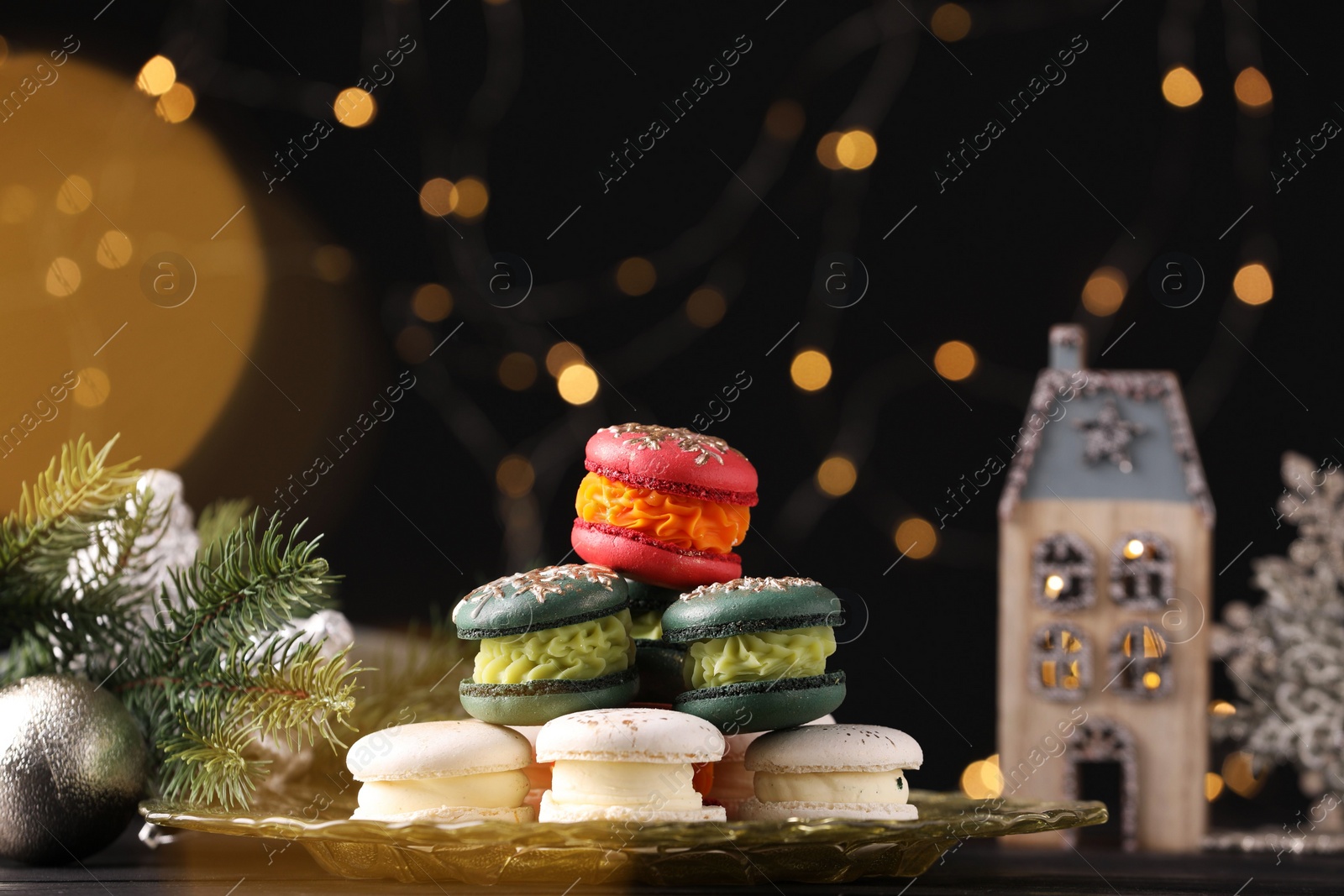 Photo of Beautifully decorated Christmas macarons and fir branches against blurred lights