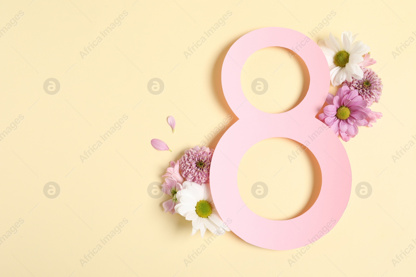 Photo of 8 March greeting card design with beautiful flowers on light yellow background, top view. Space for text