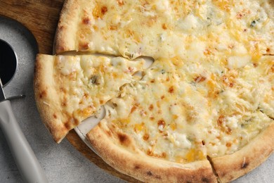 Photo of Delicious cheese pizza and cutter on light grey table, flat lay