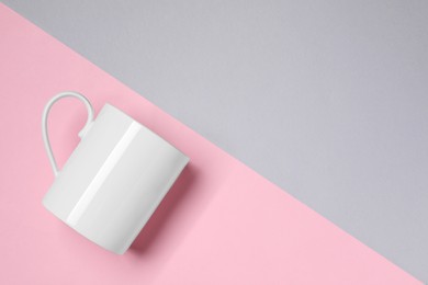 Photo of White ceramic mug on color background, top view and space for text