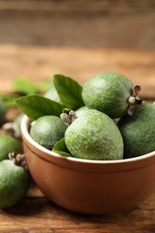 Photo of Fresh green feijoa fruits on wooden table, closeup. Space for text
