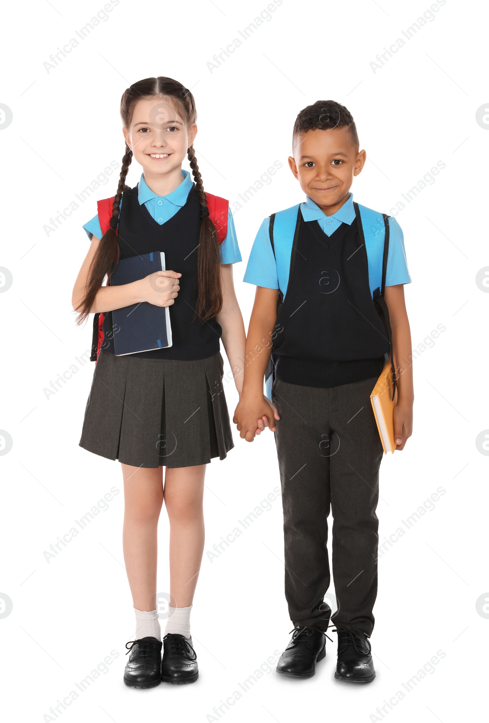 Photo of Full length portrait of cute children in school uniform with books on white background