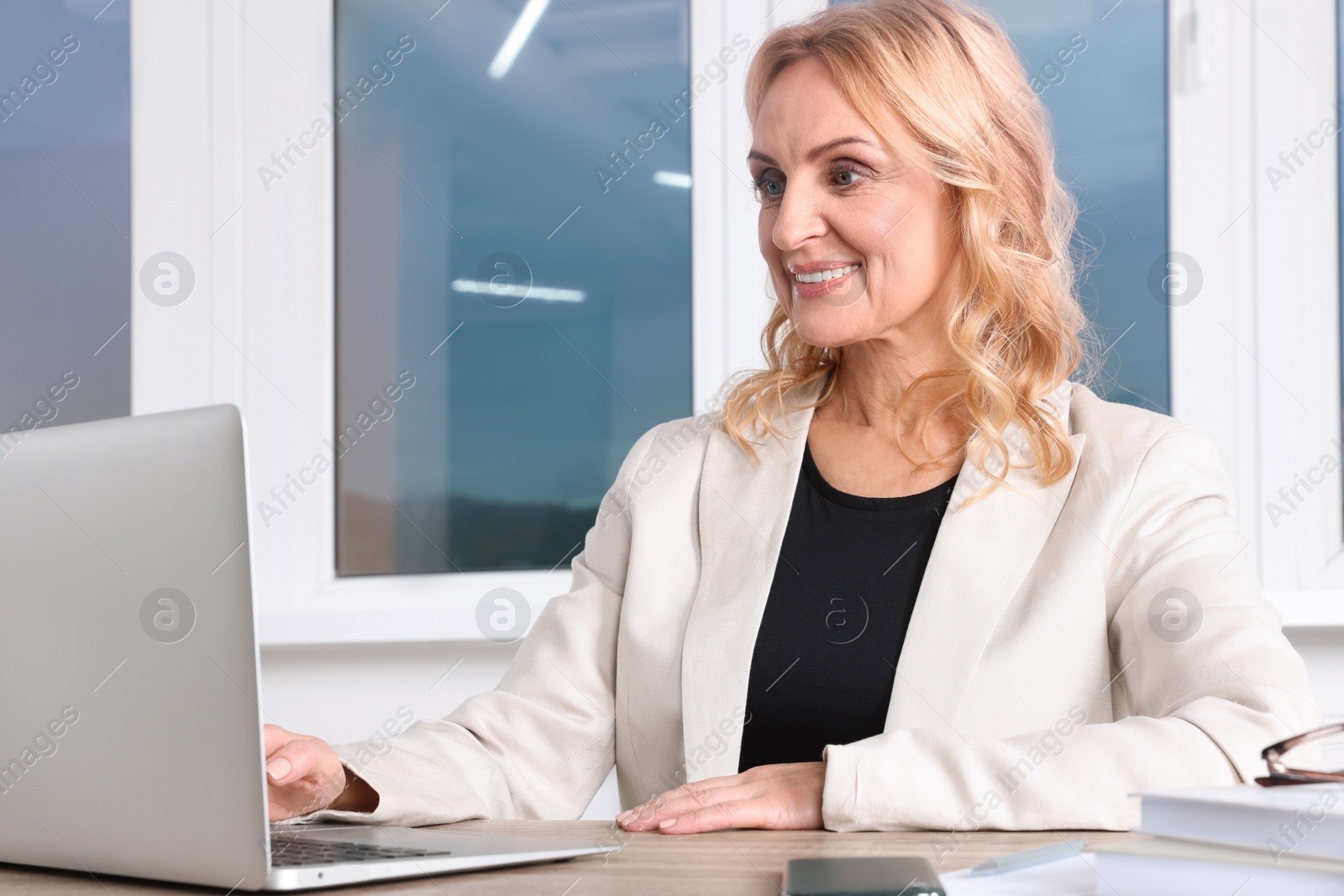 Photo of Lady boss working on laptop at desk in office. Successful businesswoman