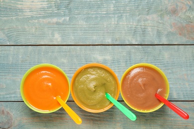 Healthy baby food on blue wooden table, flat lay. Space for text