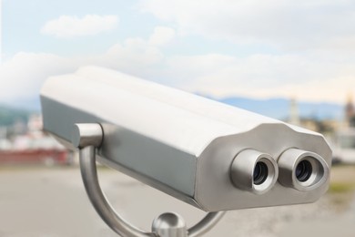 Photo of Metal tower viewer installed near beach, closeup. Mounted binoculars