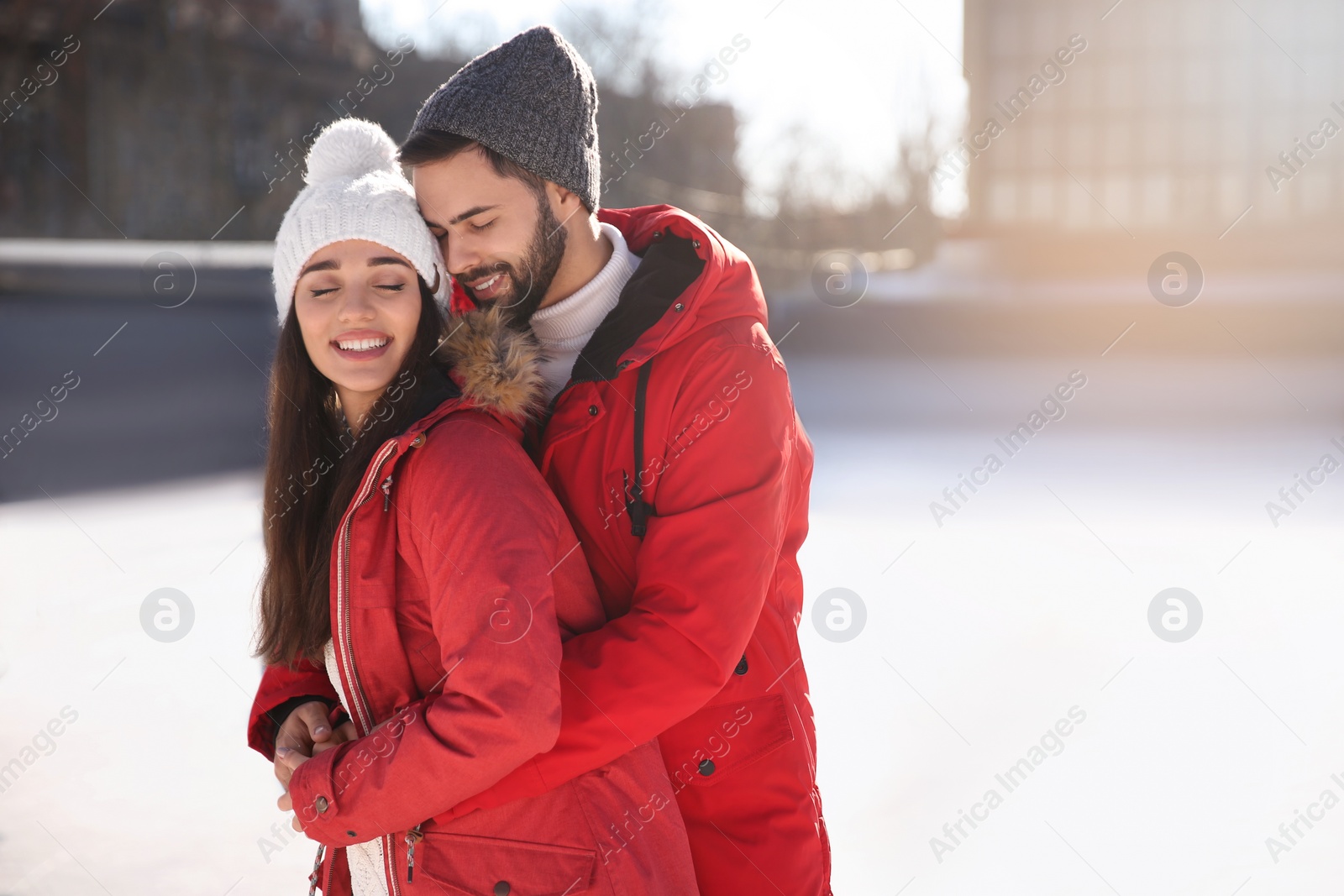 Image of Lovely couple spending time together at outdoor ice skating rink