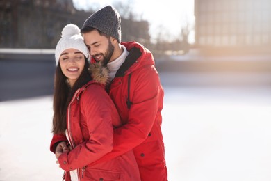 Image of Lovely couple spending time together at outdoor ice skating rink