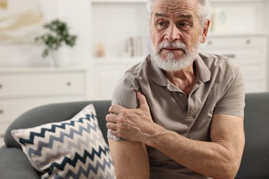 Arthritis symptoms. Man suffering from pain in shoulder at home