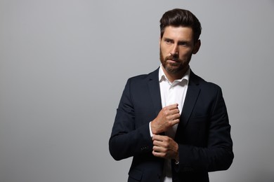 Photo of Portrait of handsome bearded man in suit looking away on light grey background. Space for text
