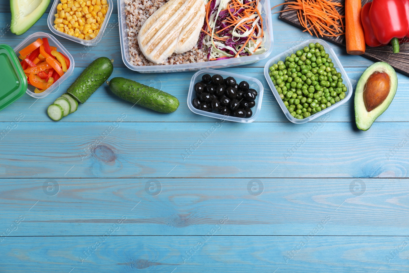Photo of Set of plastic containers with fresh food on light blue wooden table, flat lay. Space for text