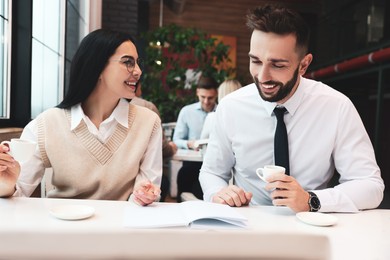 Coworkers talking in cafe during coffee break