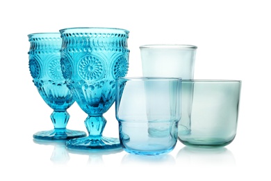 Photo of Set of colorful empty glasses on white background