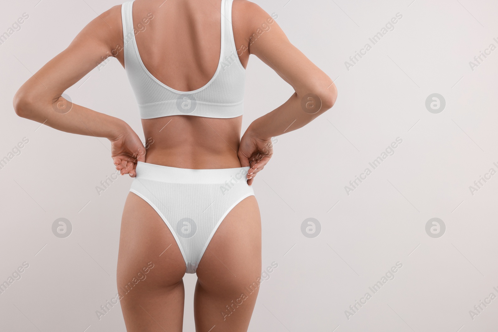 Photo of Young woman in stylish bikini on white background, closeup. Space for text