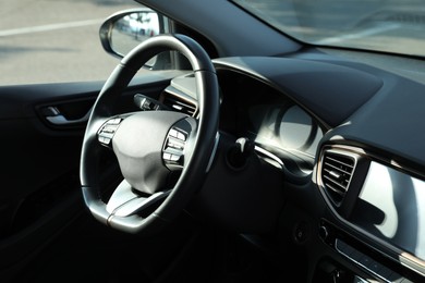 Photo of Black steering wheel and dashboard in modern car