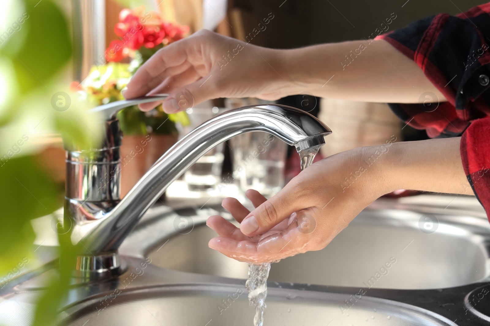 Photo of Woman washing hands in kitchen, closeup view