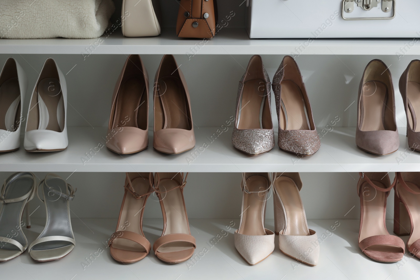 Photo of Different stylish women's shoes on shelving unit