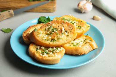 Photo of Plate with delicious homemade garlic bread on table