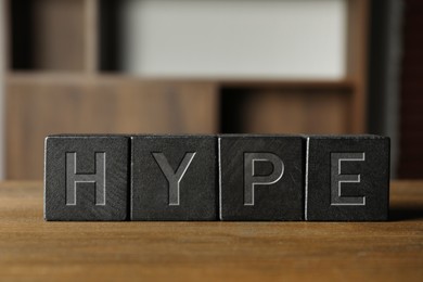 Word Hype of black cubes with letters on wooden table