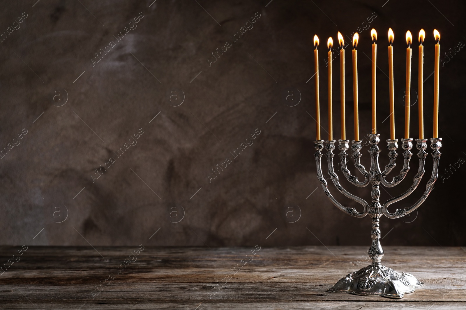 Photo of Hanukkah menorah on table against grey background