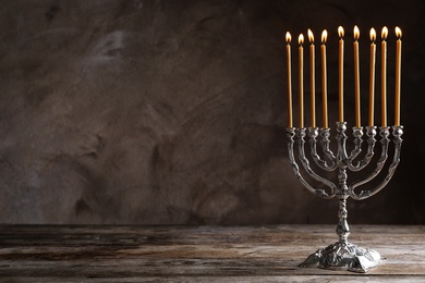 Hanukkah menorah on table against grey background