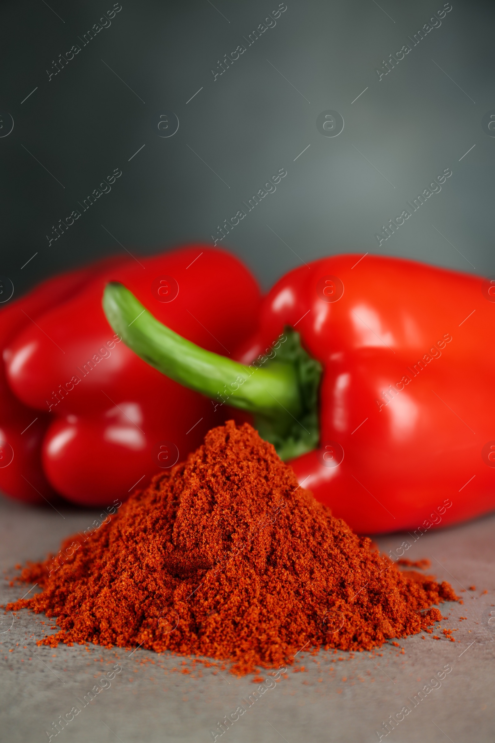 Photo of Heap of paprika with sweet bell peppers on light grey table, closeup