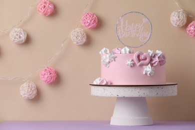 Photo of Beautifully decorated birthday cake on violet table