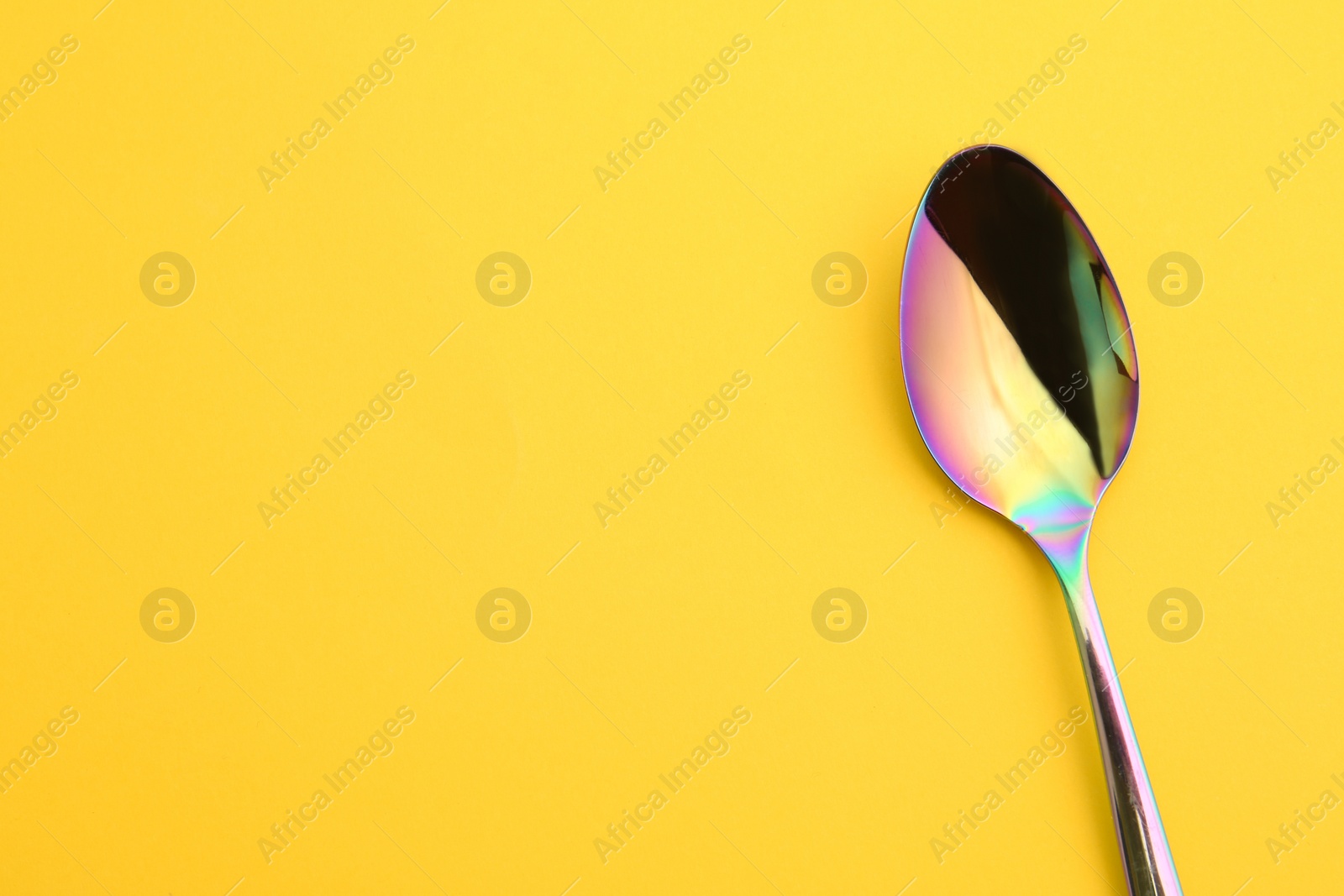 Photo of Clean tea spoon and space for text on color background, top view