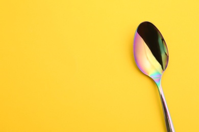 Clean tea spoon and space for text on color background, top view