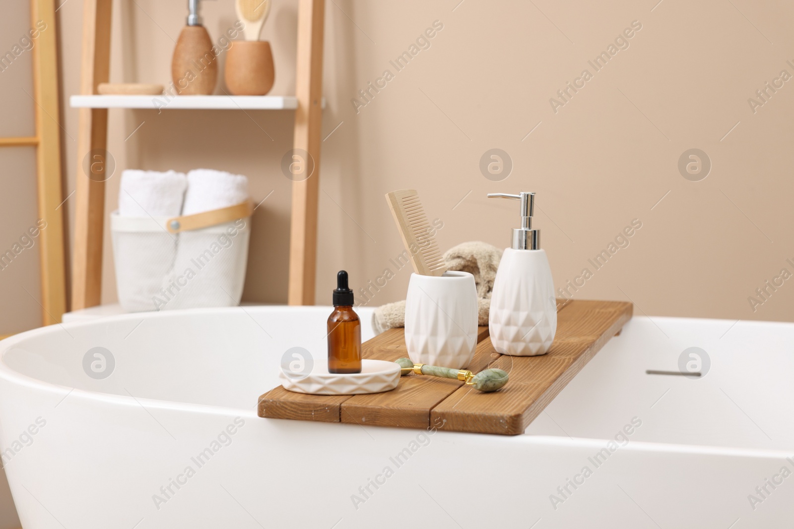 Photo of Different personal care products and accessories on bath tub in bathroom