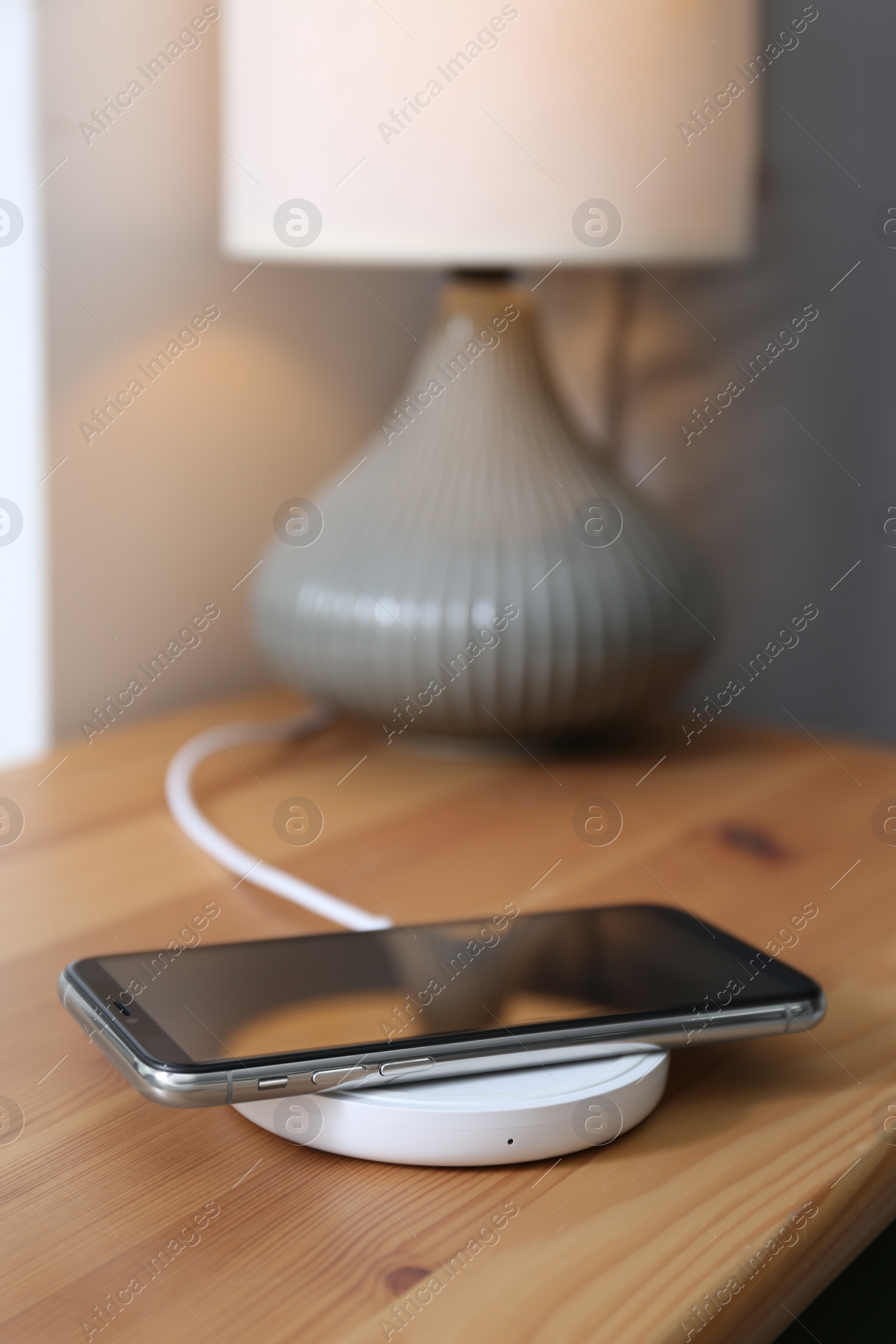 Photo of Smartphone charging on wireless pad in room
