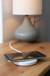 Photo of Smartphone charging on wireless pad in room