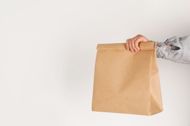 Woman holding paper bag on white background. Mockup for design