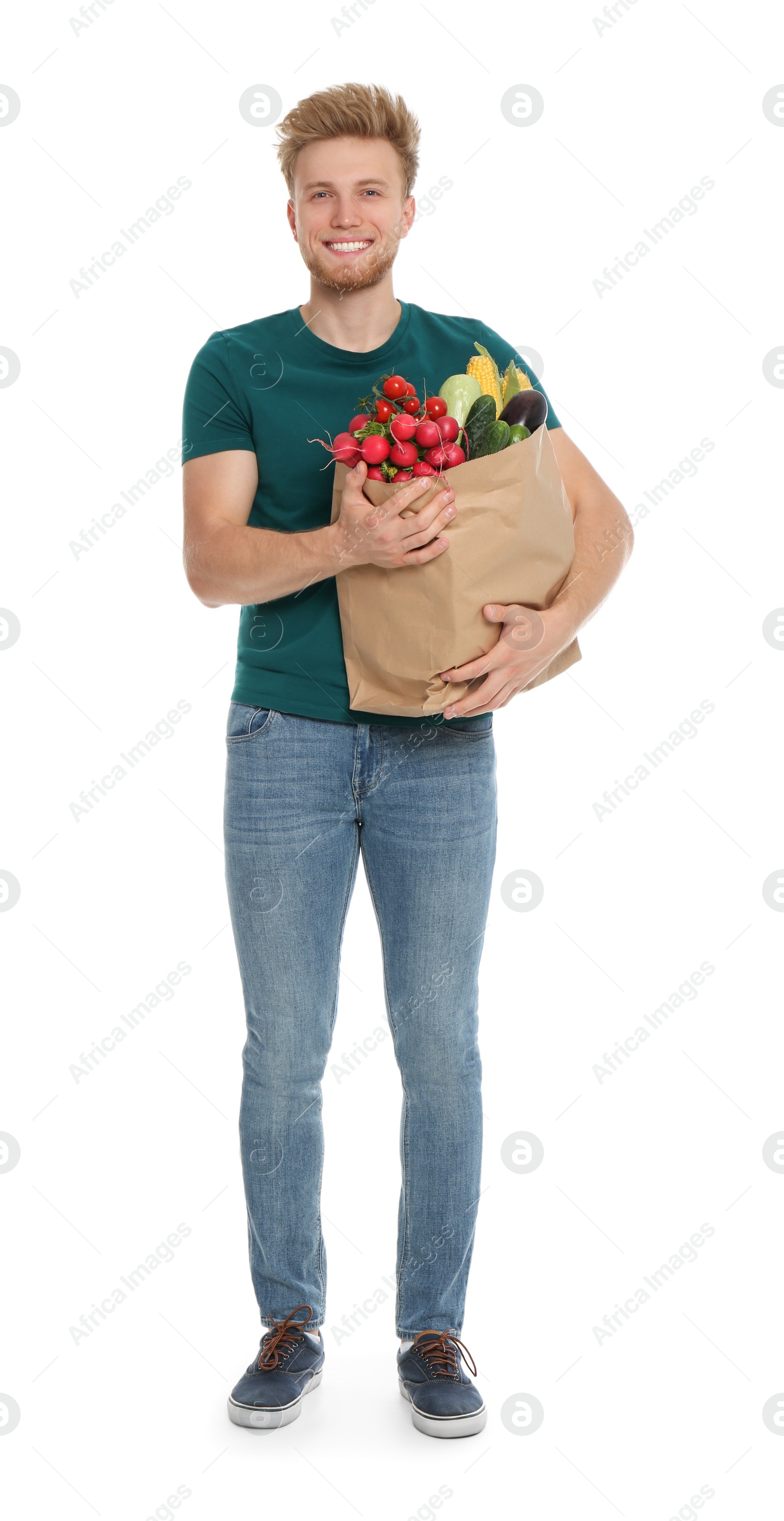 Photo of Young man with bag of fresh vegetables on white background