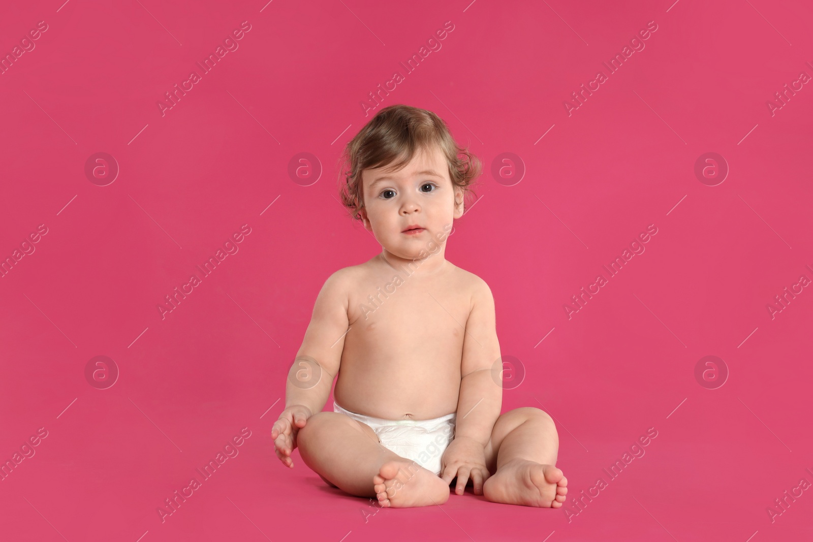 Photo of Cute little baby in diaper on pink background