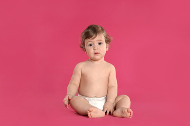 Photo of Cute little baby in diaper on pink background