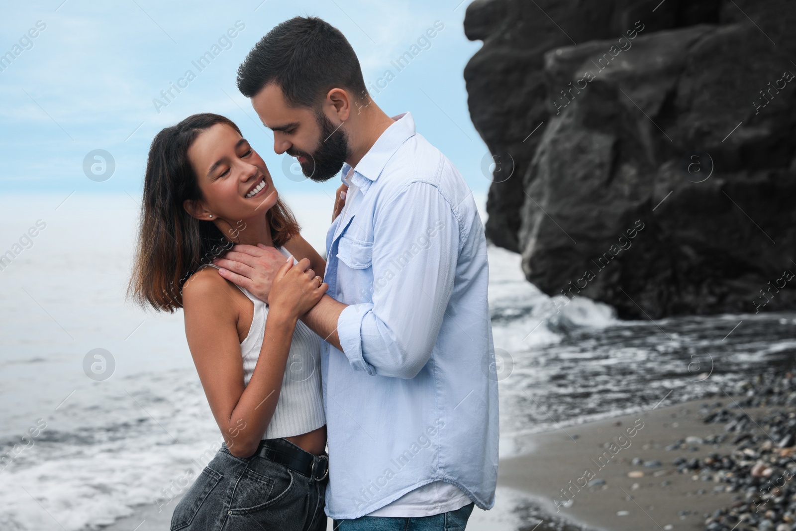 Photo of Happy young couple spending time together on beach near sea