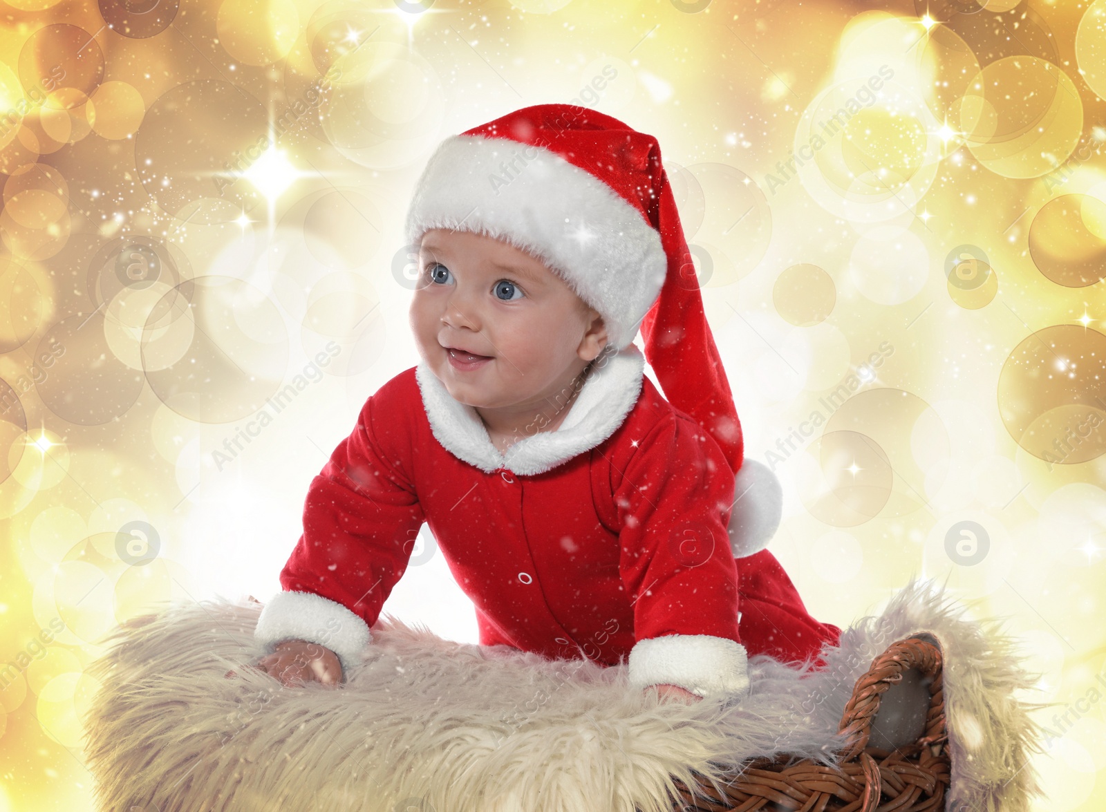 Image of Cute baby in wicker basket against blurred lights. Christmas celebration