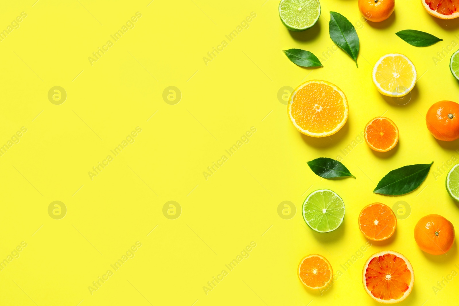 Photo of Different citrus fruits and leaves on color background, flat lay. Space for text