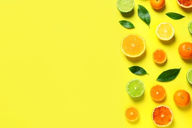 Photo of Different citrus fruits and leaves on color background, flat lay. Space for text