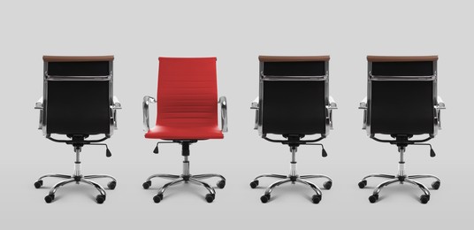 Image of Vacant position. Red office chair among black ones on light grey background, banner design