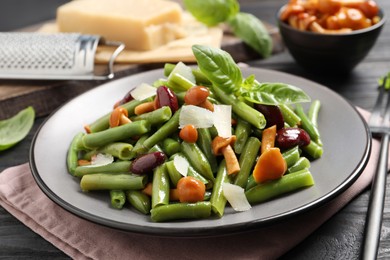 Photo of Delicious salad with green beans, mushrooms and cheese served on wooden table